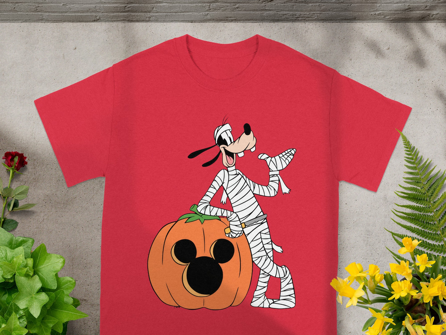 Red t-shirt with Goofy as a mummy next to a Mickey Mouse pumpkin.