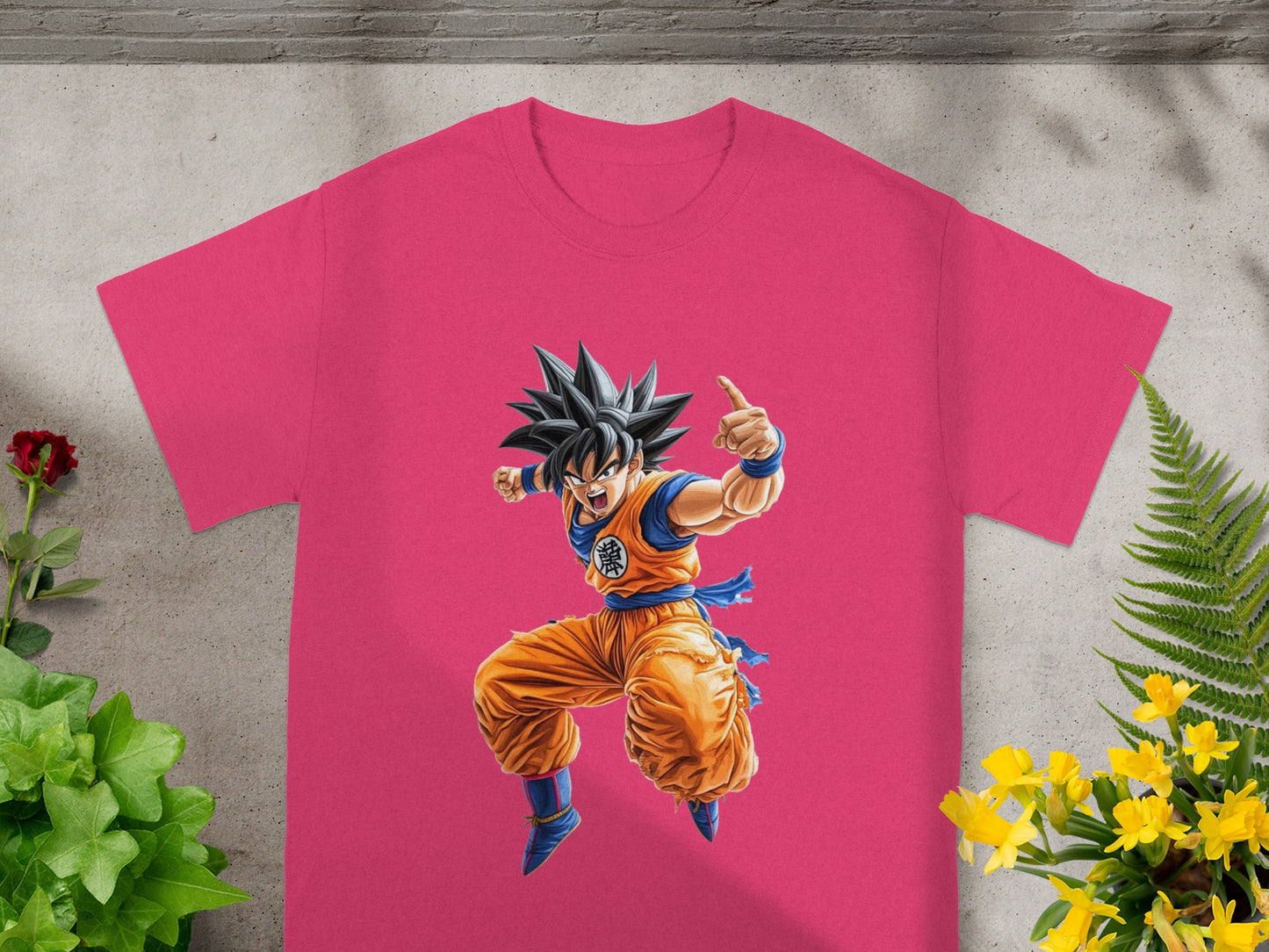 Goku in orange gi, arms outstretched, on a pink t-shirt.