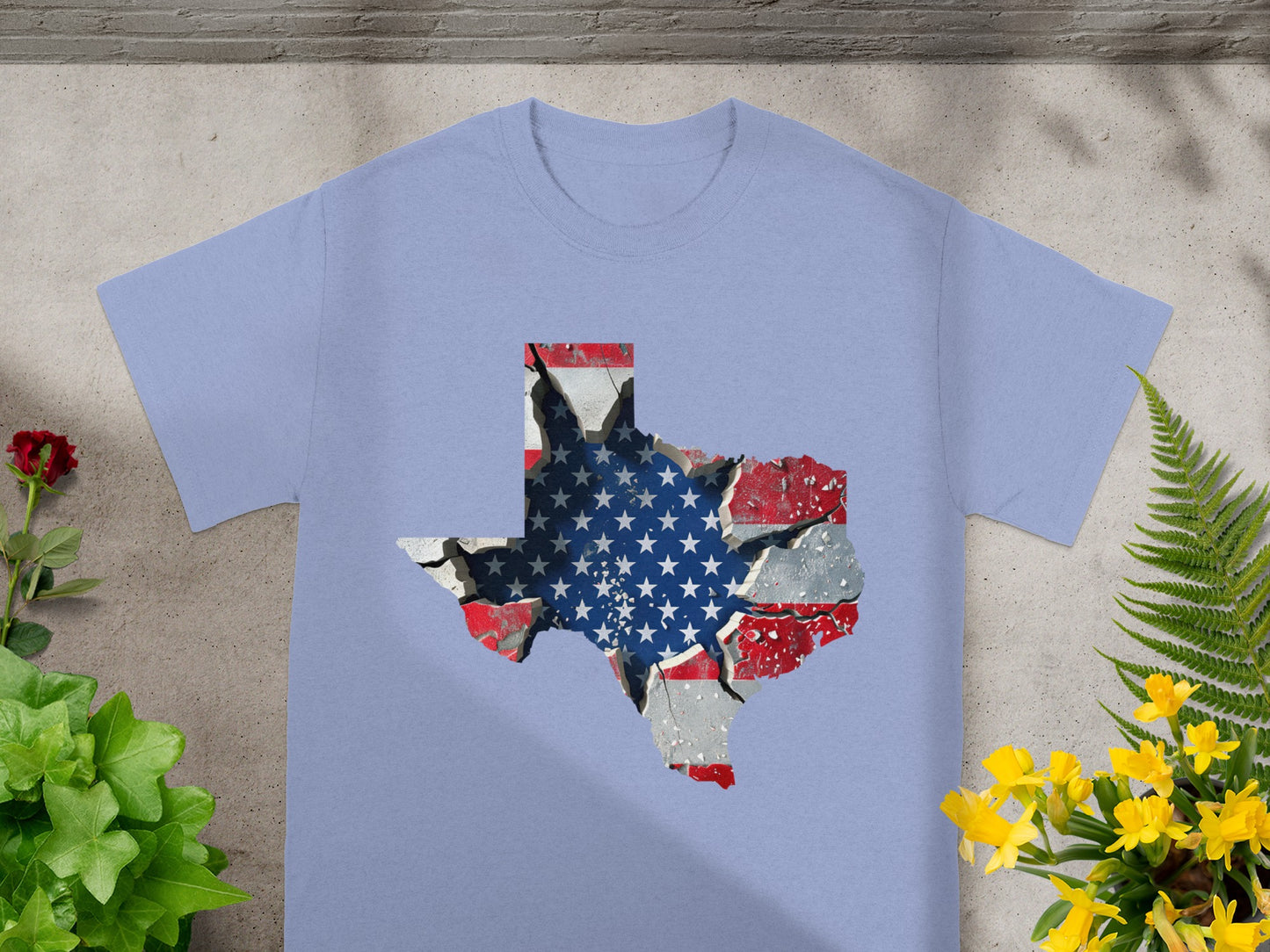 Light blue t-shirt with a cracked Texas shape featuring the American flag.
