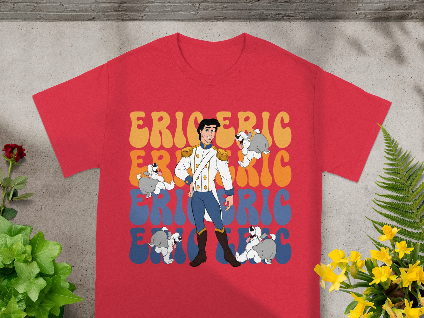 Prince Eric surrounded by dogs on a red t-shirt with colorful "Eric" text.