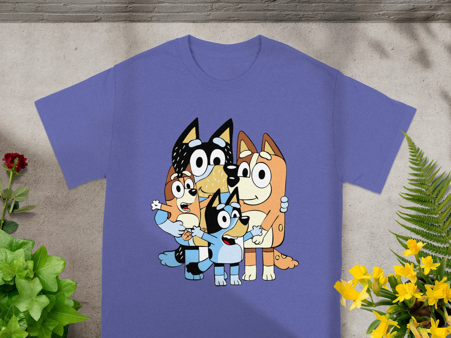 Bluey and Bingo characters family hug on a purple t-shirt.