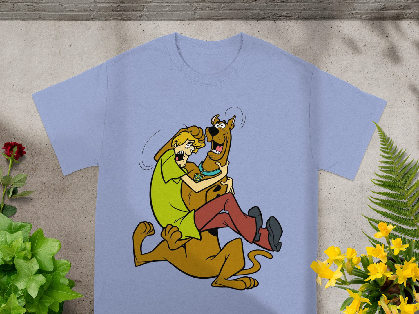 Shaggy and Scooby-Doo in a humorous cartoon embrace on a light blue t-shirt.
