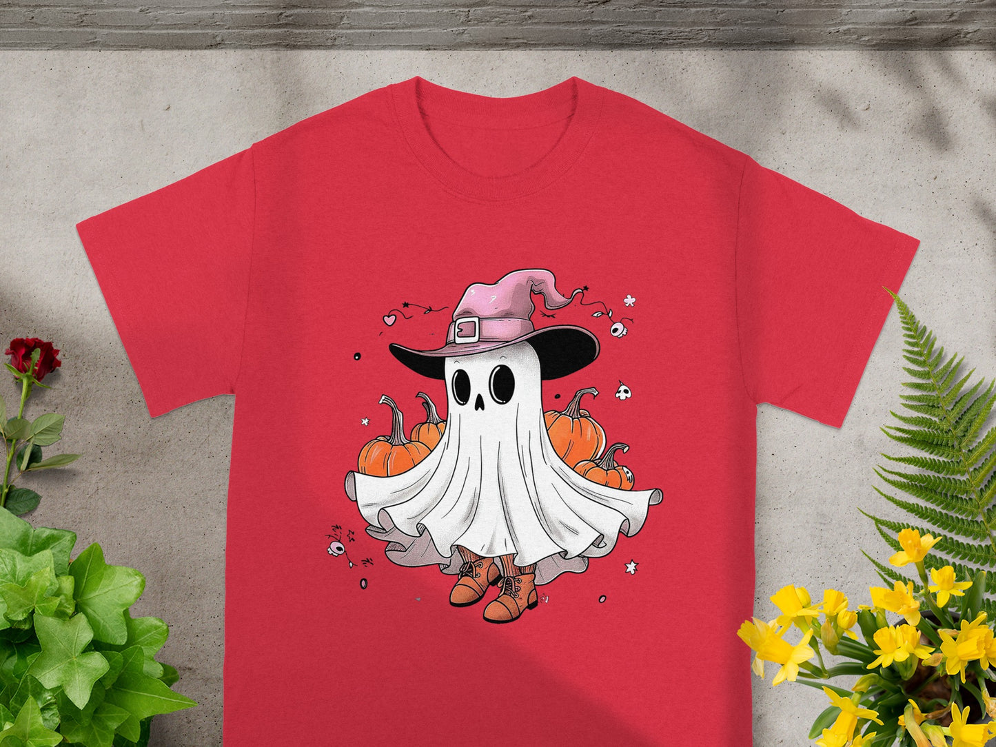 Red t-shirt with a cartoon ghost wearing a pink witch hat and boots, surrounded by pumpkins.