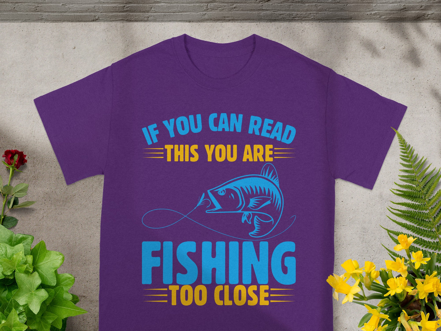 Purple t-shirt with "If you can read this you are fishing too close" text and fish graphic.