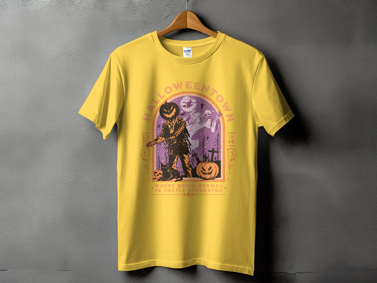 Yellow t-shirt with Halloween town graphic featuring a scarecrow, ghost, and pumpkins.