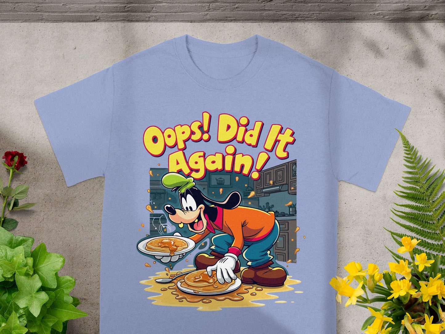 Goofy cartoon character on a light purple t-shirt with "Oops! Did It Again!" text.