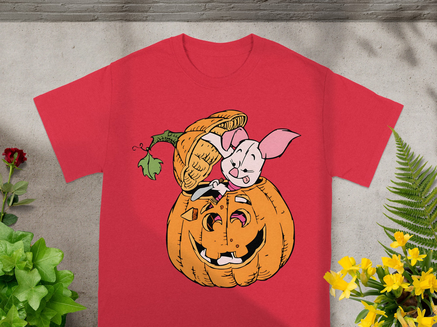 Piglet peeking out of a jack-o'-lantern on a red t-shirt.