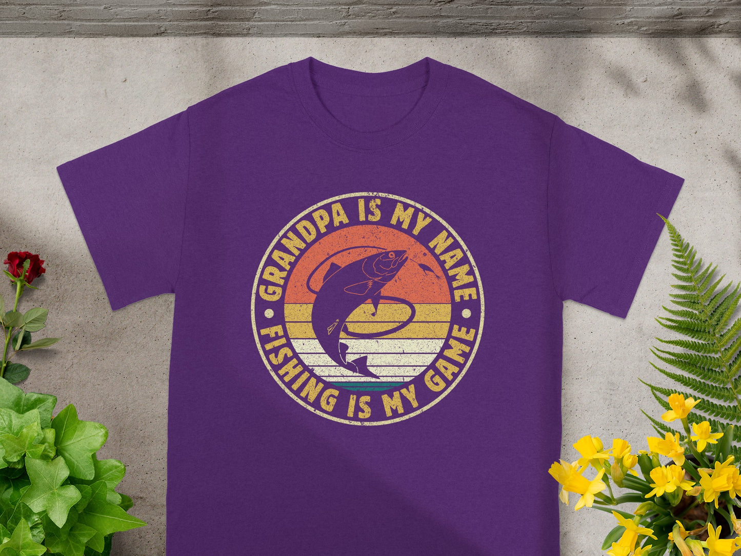 Purple t-shirt with a fishing graphic and text: "Grandpa is my name fishing is my game."