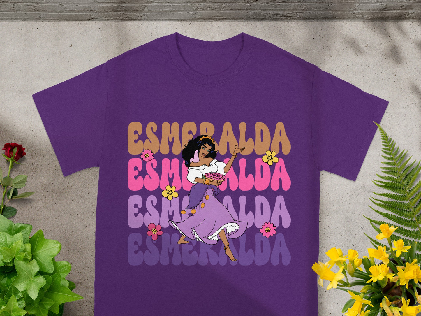 Esmeralda dancing in a purple shirt with colorful text.