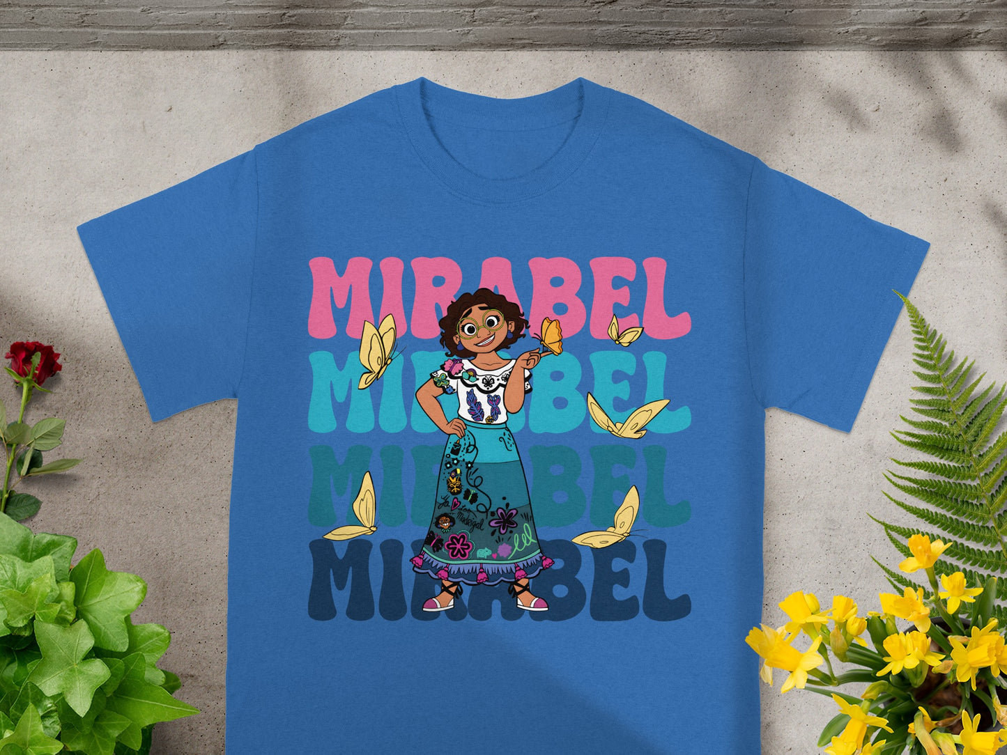 Mirabel from Encanto on a blue t-shirt with butterflies and colorful text.