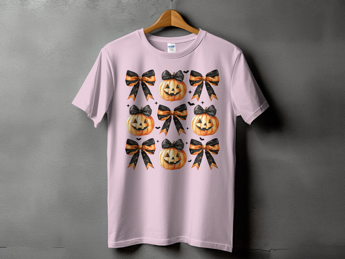Pink t-shirt with a repeated pattern of Halloween pumpkins and bows.