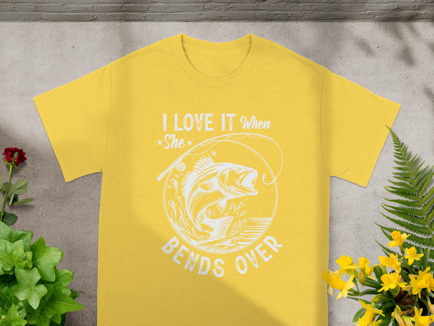 Yellow t-shirt with white graphic saying "I LOVE IT When She BENDS OVER" and a jumping fish.