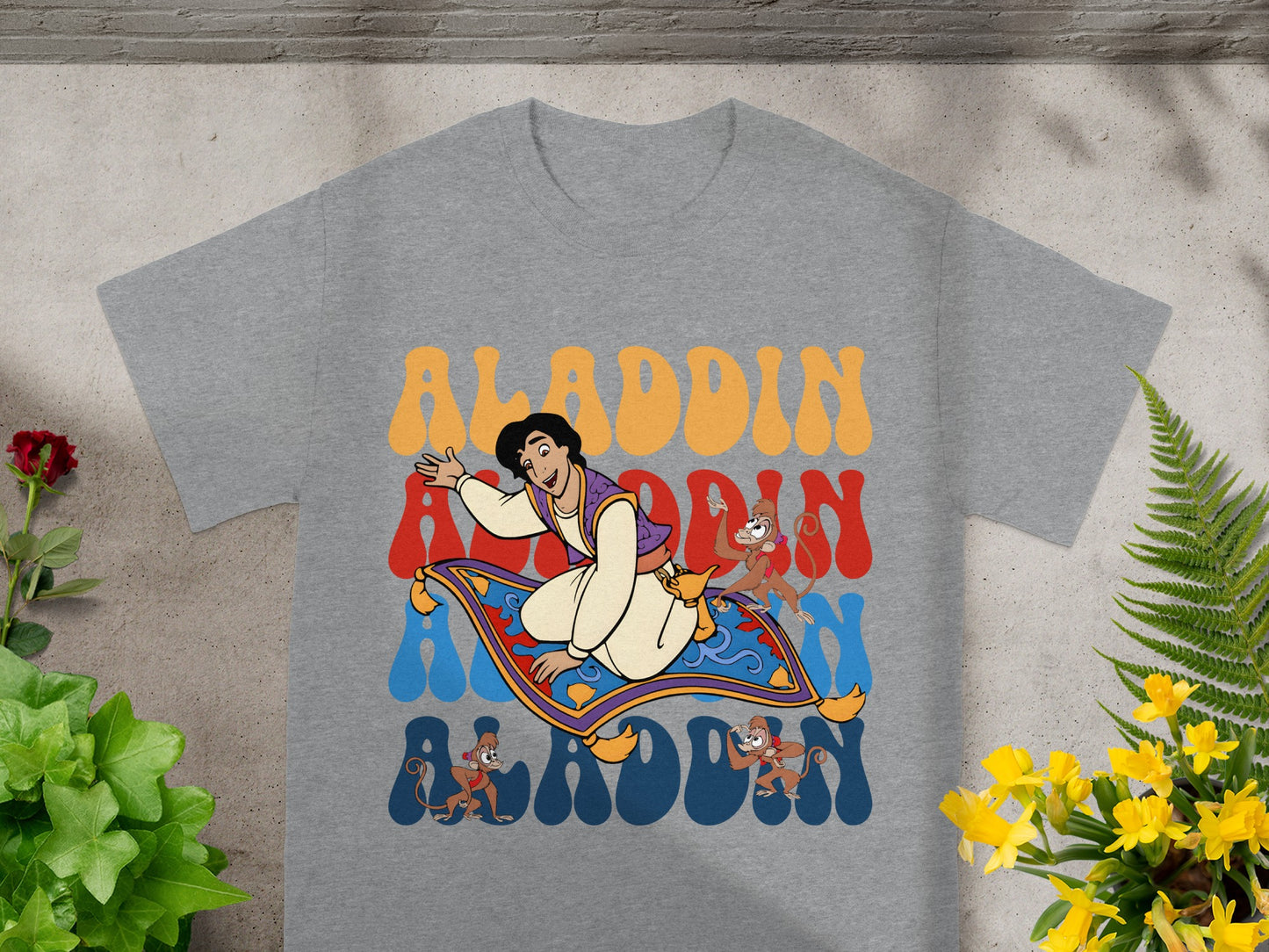Grey t-shirt with Aladdin, Abu, and Magic Carpet graphic and "Aladdin" text.