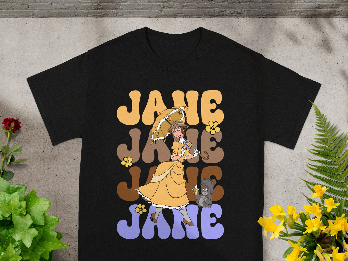 Black t-shirt with "JANE" repeated in retro lettering and cartoon Jane with umbrella.