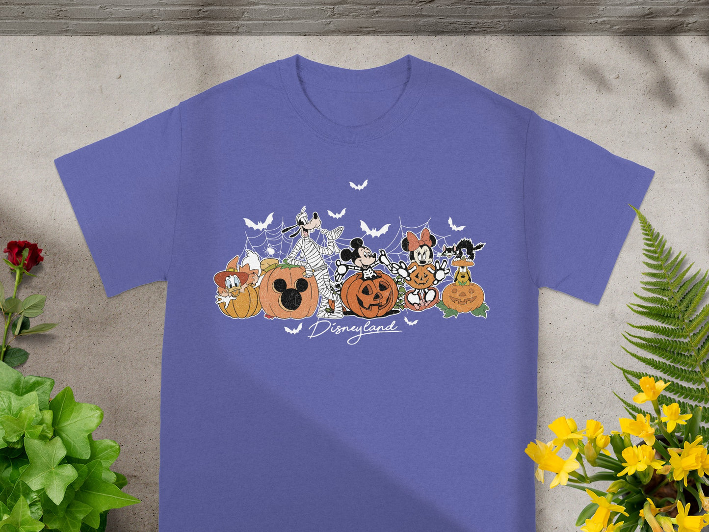 Disneyland Halloween graphic with Disney characters and pumpkins on purple t-shirt.