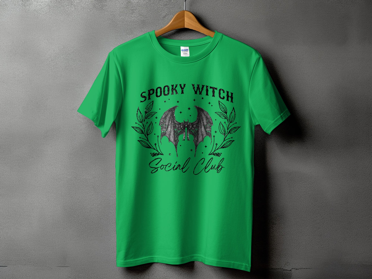 Green t-shirt with "Spooky Witch Social Club" text and bat wings graphic.