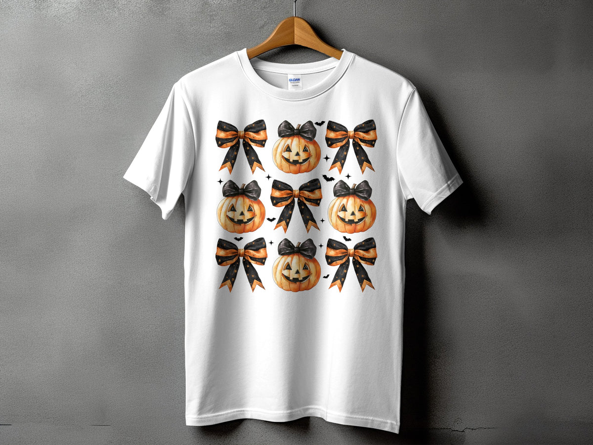 White t-shirt with a pattern of pumpkins and black and orange bows.