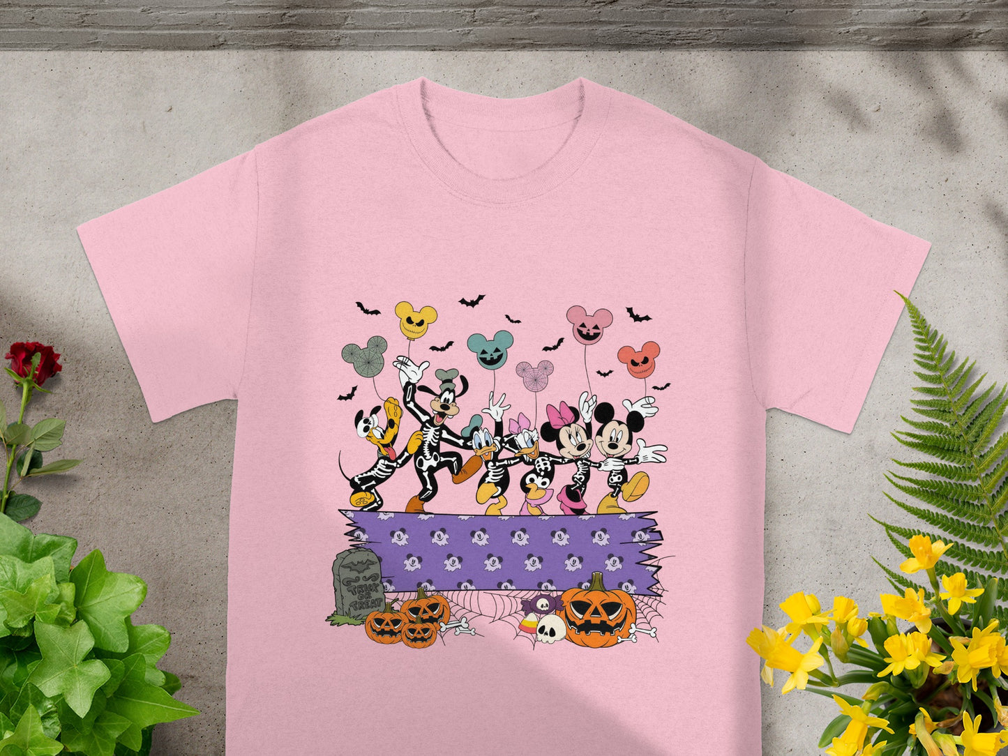 Disney characters in skeleton costumes dance above pumpkins and a tombstone reading "Trick or Treat."