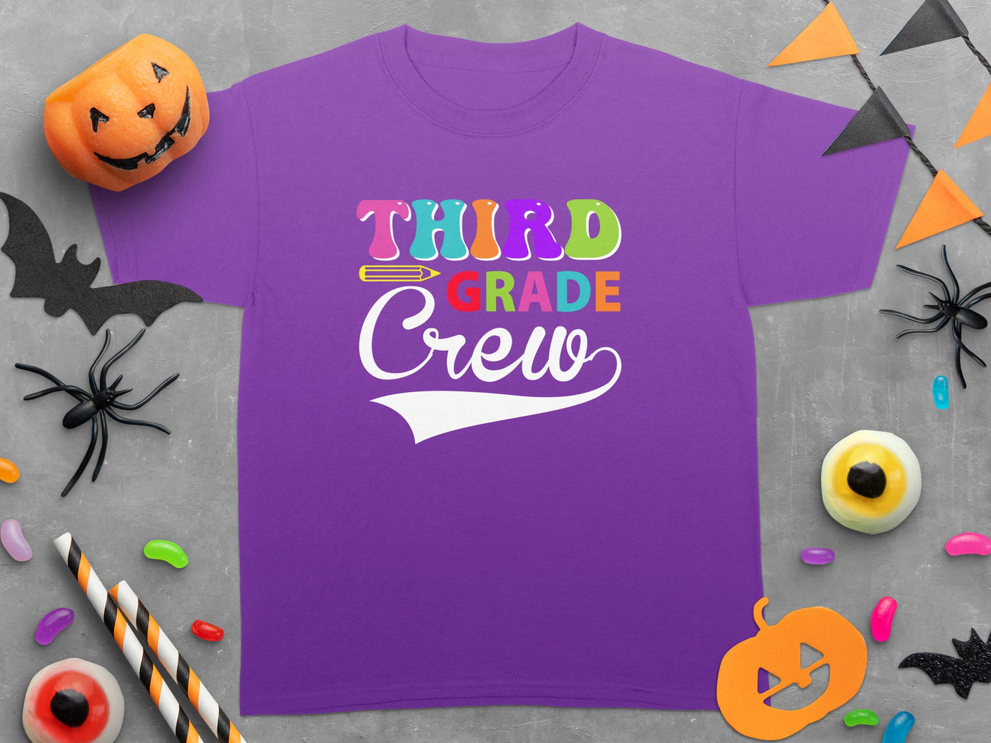 Purple t-shirt with "Third Grade Crew" text in colorful lettering and Halloween decorations.
