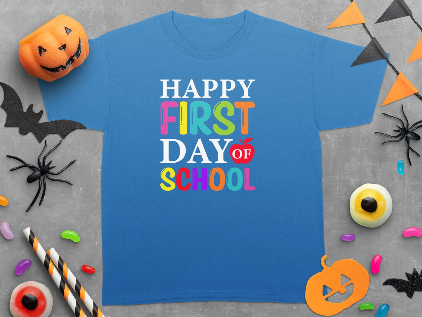 Blue t-shirt with "Happy First Day of School" text and Halloween decorations.