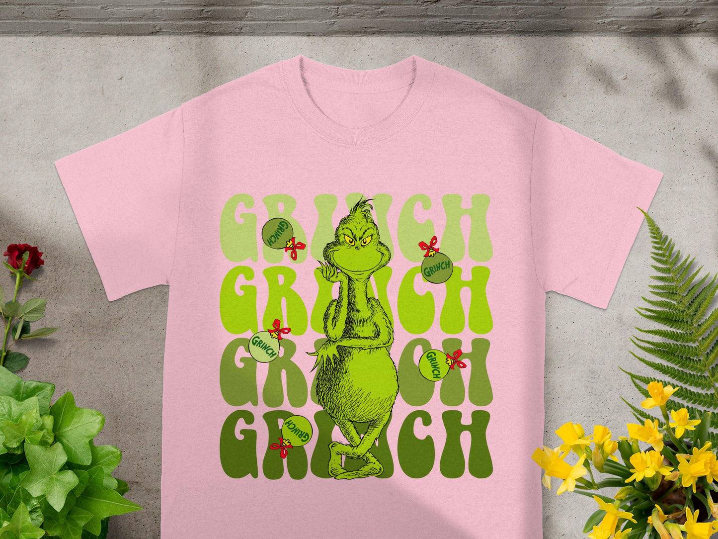 Pink t-shirt with Grinch graphic and text.