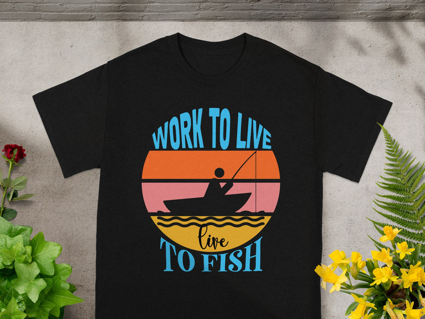 Black t-shirt with sunset graphic and text "WORK TO LIVE live TO FISH".