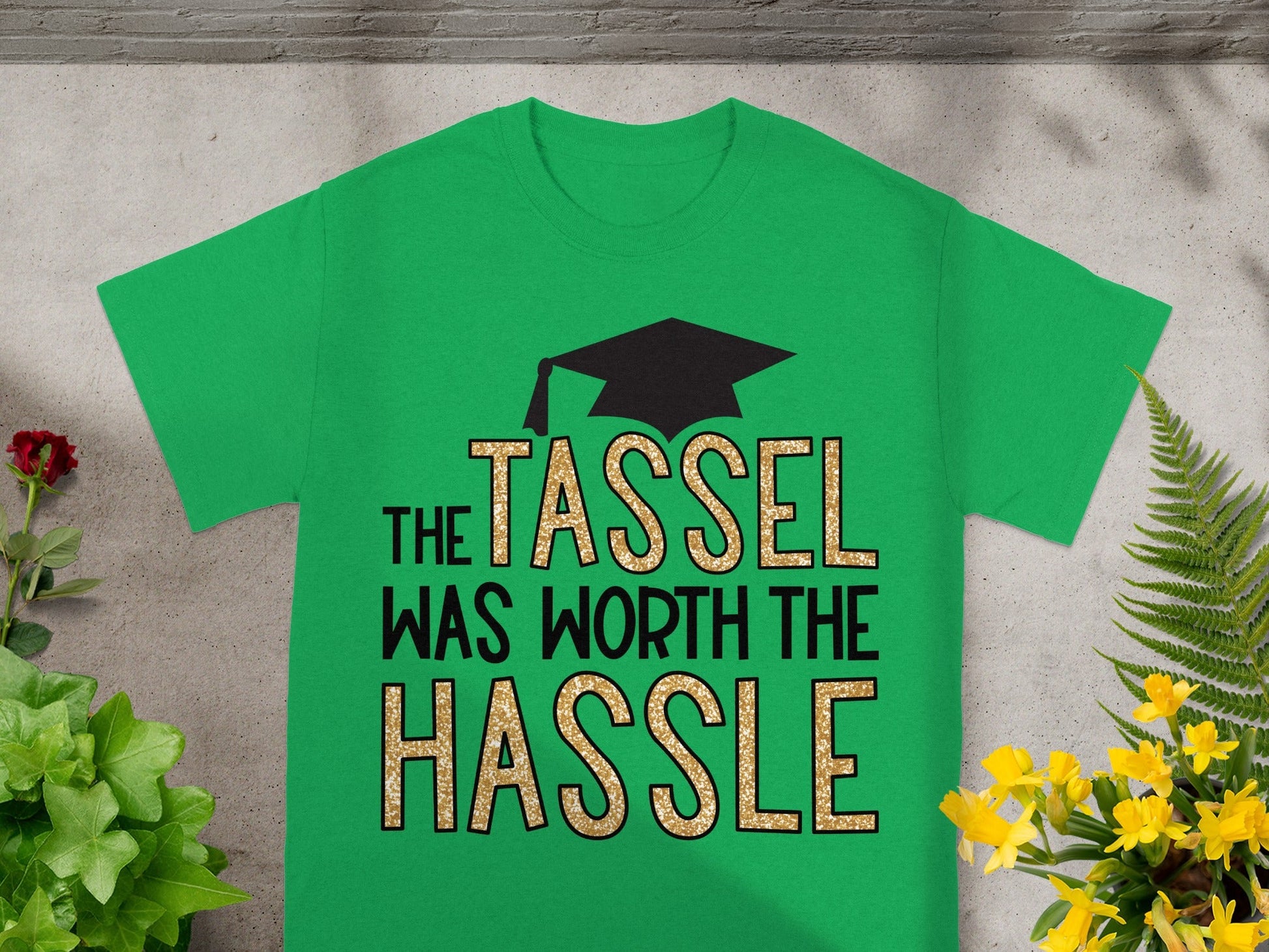 Green t-shirt with "The Tassel Was Worth The Hassle" text and graduation cap design.