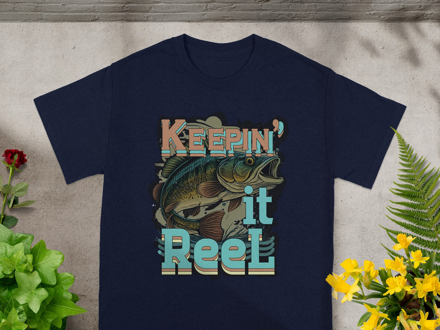 Navy t-shirt with "Keepin' it Reel" text and a leaping fish graphic.