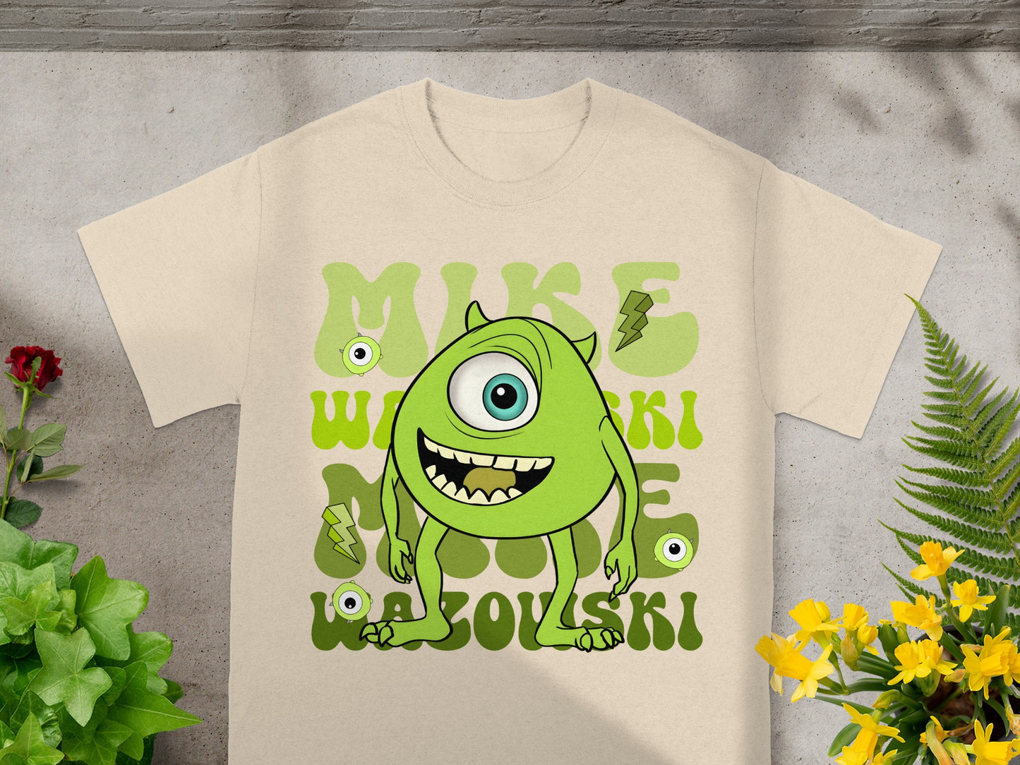 Mike Wazowski character on a beige t-shirt with green text.
