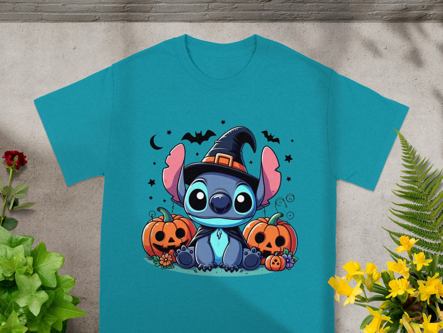 Stitch in witch hat with pumpkins and bats on a teal t-shirt.