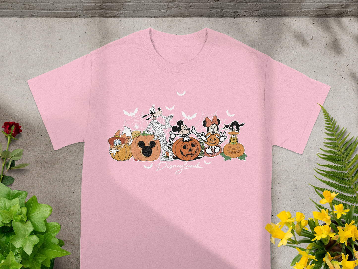 Pink t-shirt with Disney characters and pumpkins, text "Disneyland".