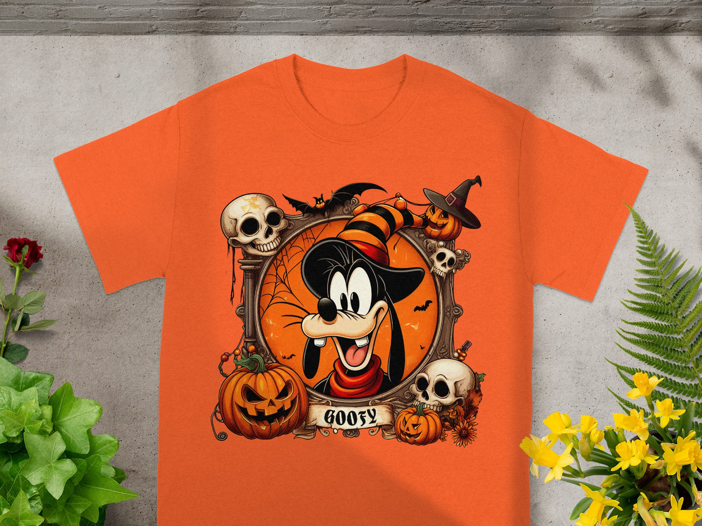 Orange t-shirt featuring Goofy in a Halloween frame with pumpkins and skulls.