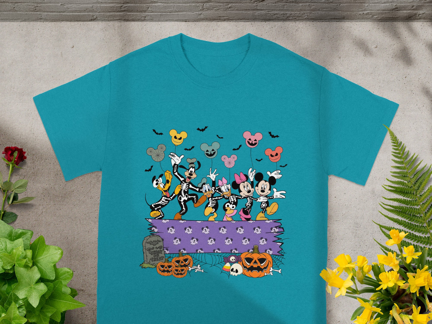 Mickey Mouse characters in skeleton costumes dance with Halloween balloons and pumpkins.