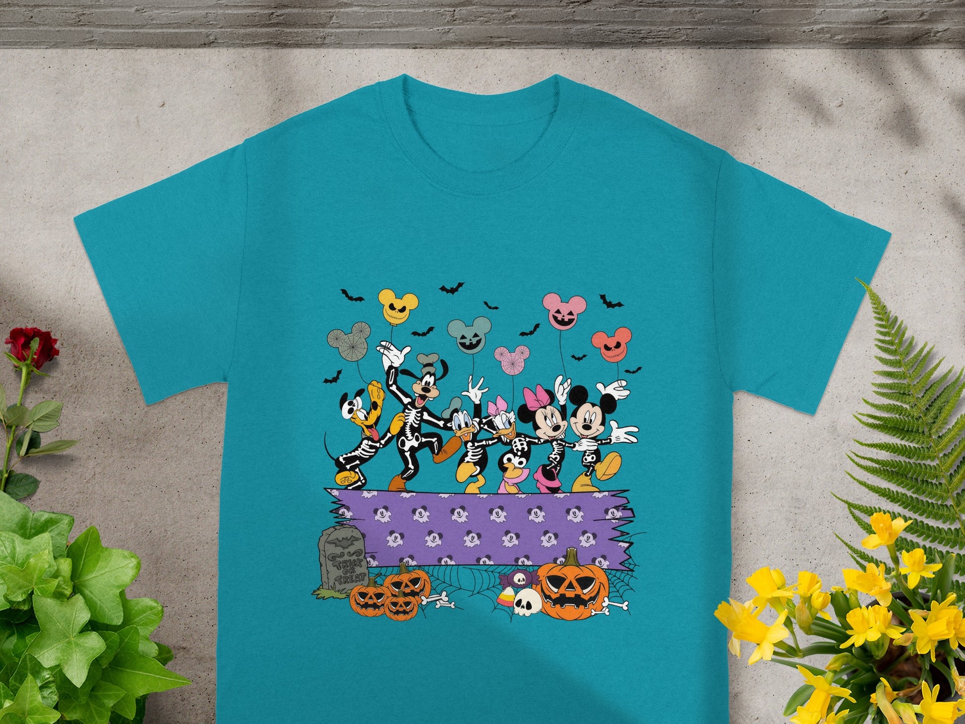 Mickey Mouse characters in skeleton costumes dance with Halloween balloons and pumpkins.