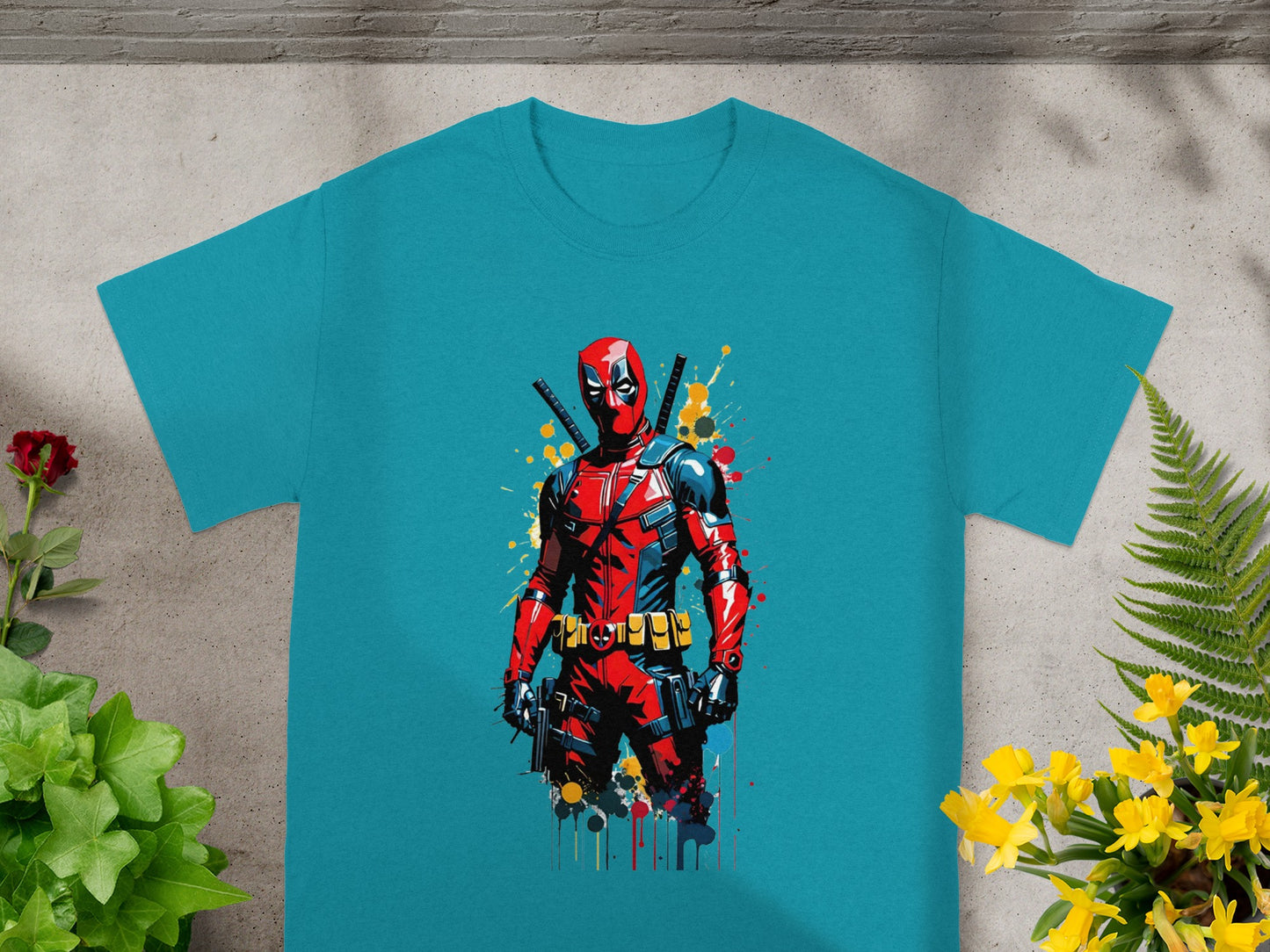 Teal t-shirt featuring a vibrant Deadpool graphic with red and black suit and katanas.