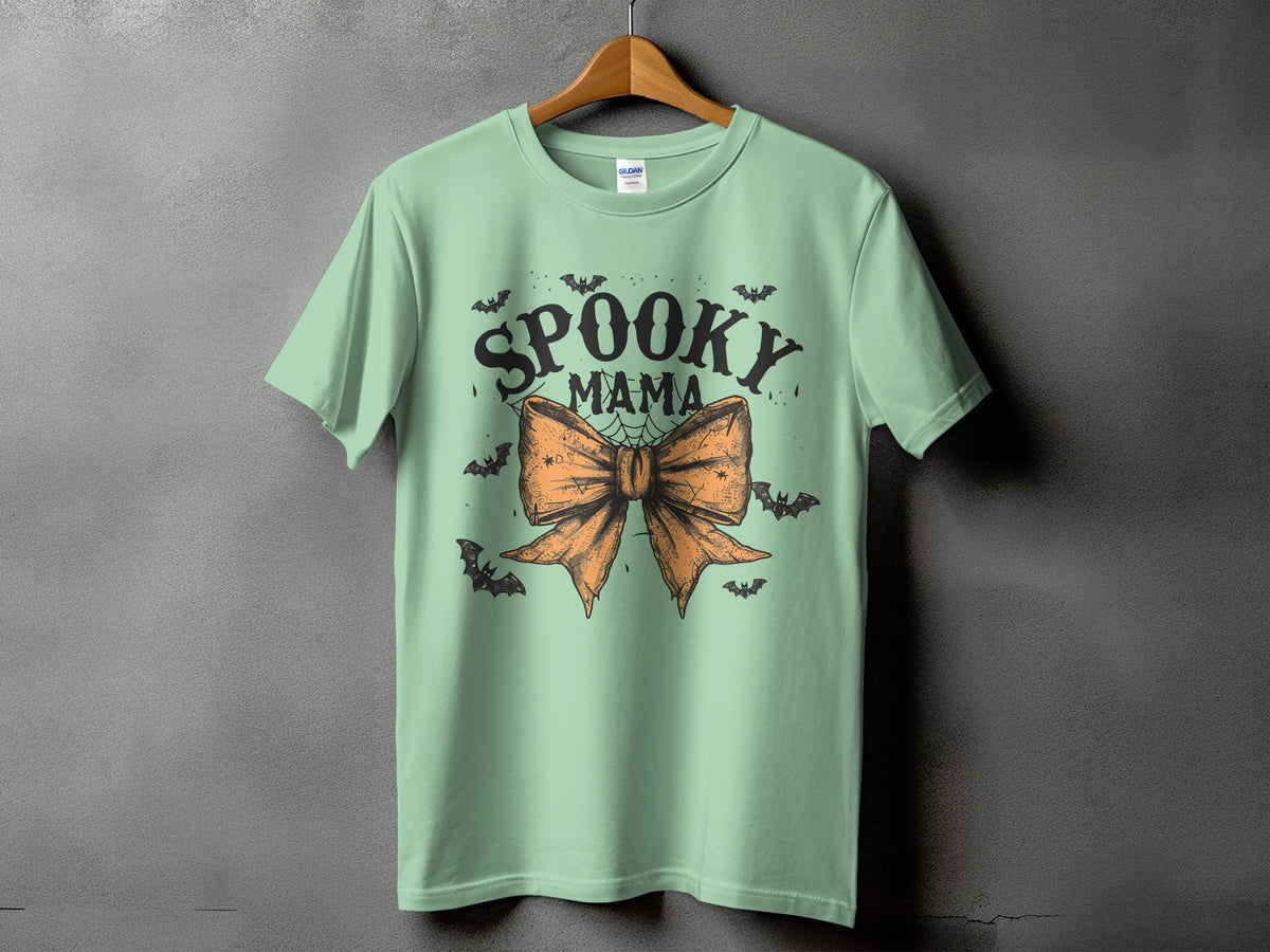 Mint green t-shirt with "Spooky Mama" text and orange bow graphic.