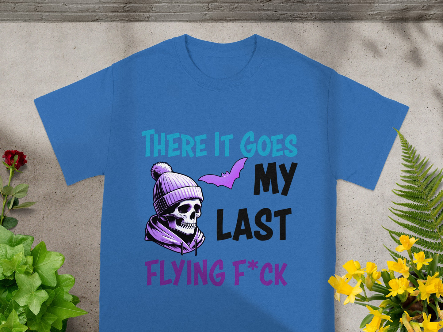 Blue t-shirt with skull, beanie, bat, and text "There it goes my last flying f*ck".