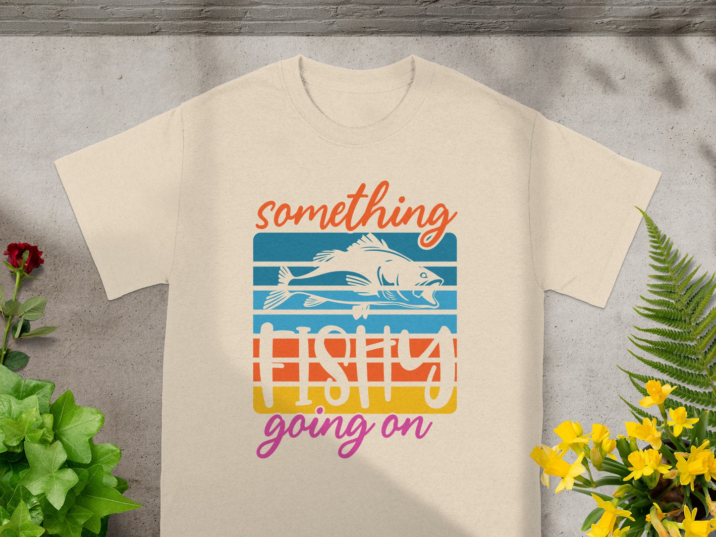 Cream t-shirt with "something fishy going on" text and a stylized fish design.