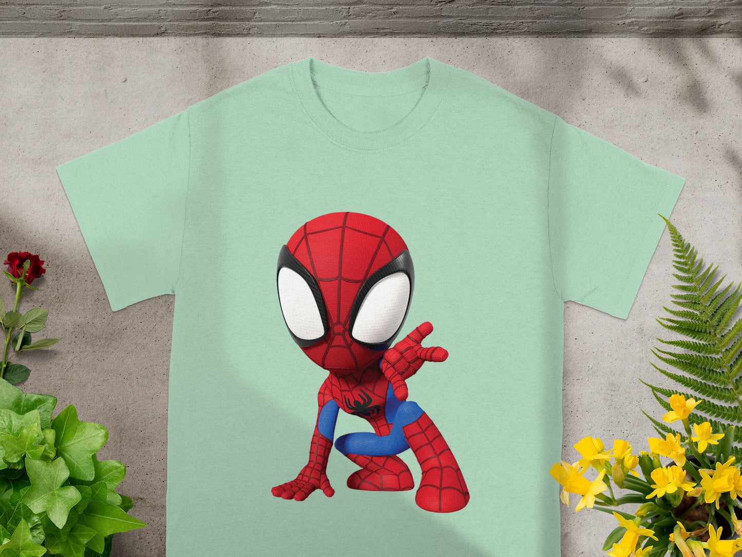 Light mint green t-shirt with a cartoon Spiderman graphic in crouched pose.