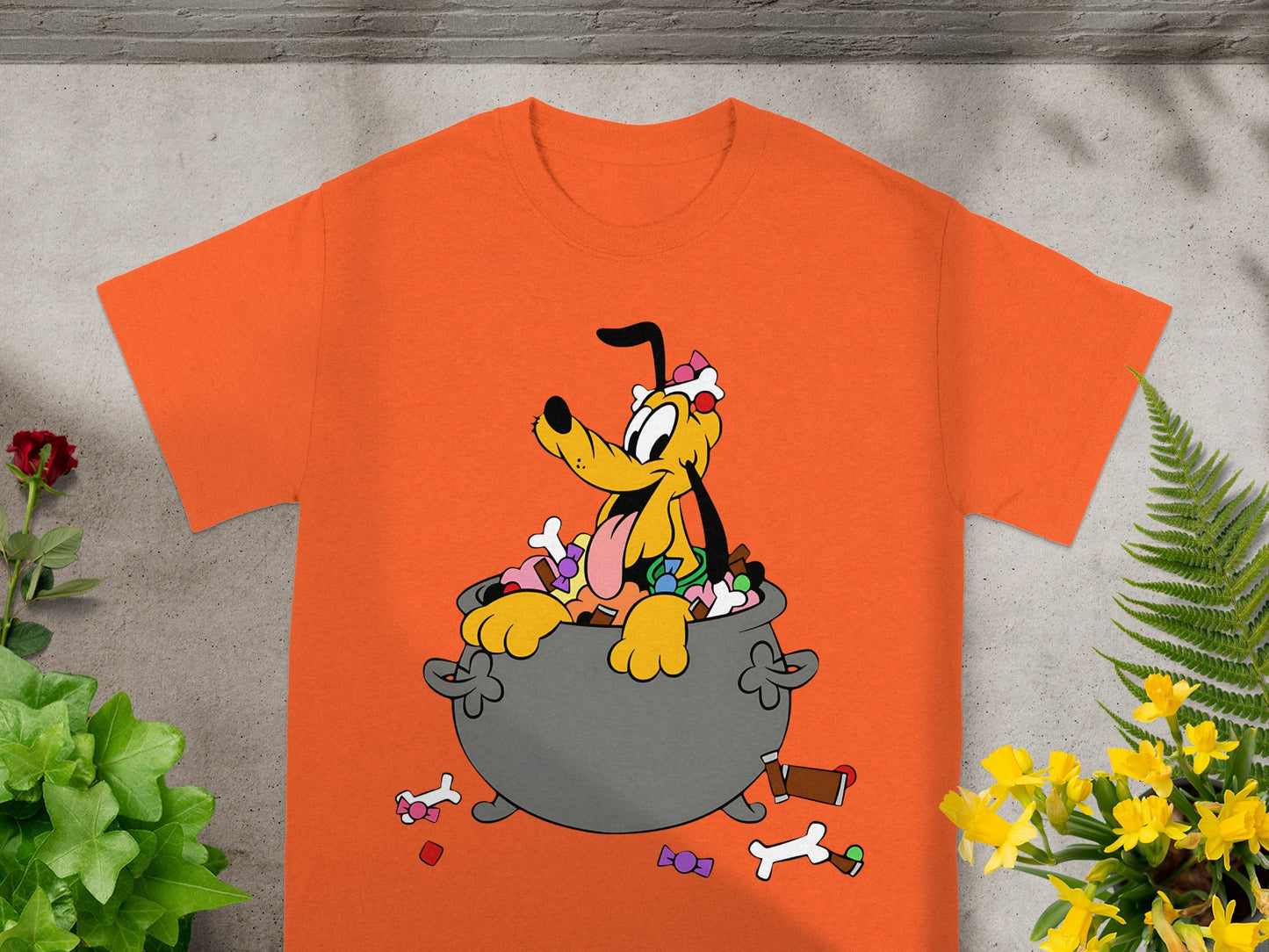 Pluto sits in a cauldron overflowing with candy and bones.