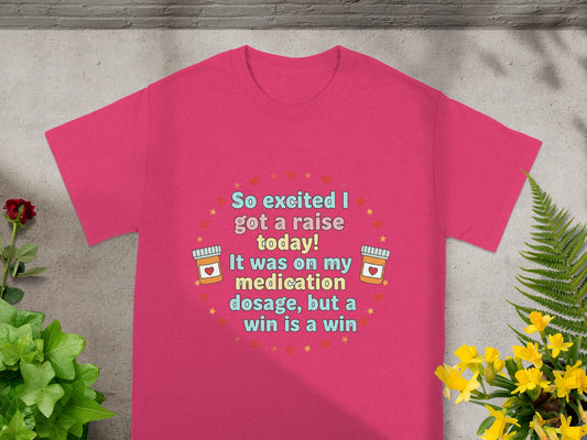 Pink t-shirt with text "So excited I got a raise today! It was on my medication dosage, but a win is a win".