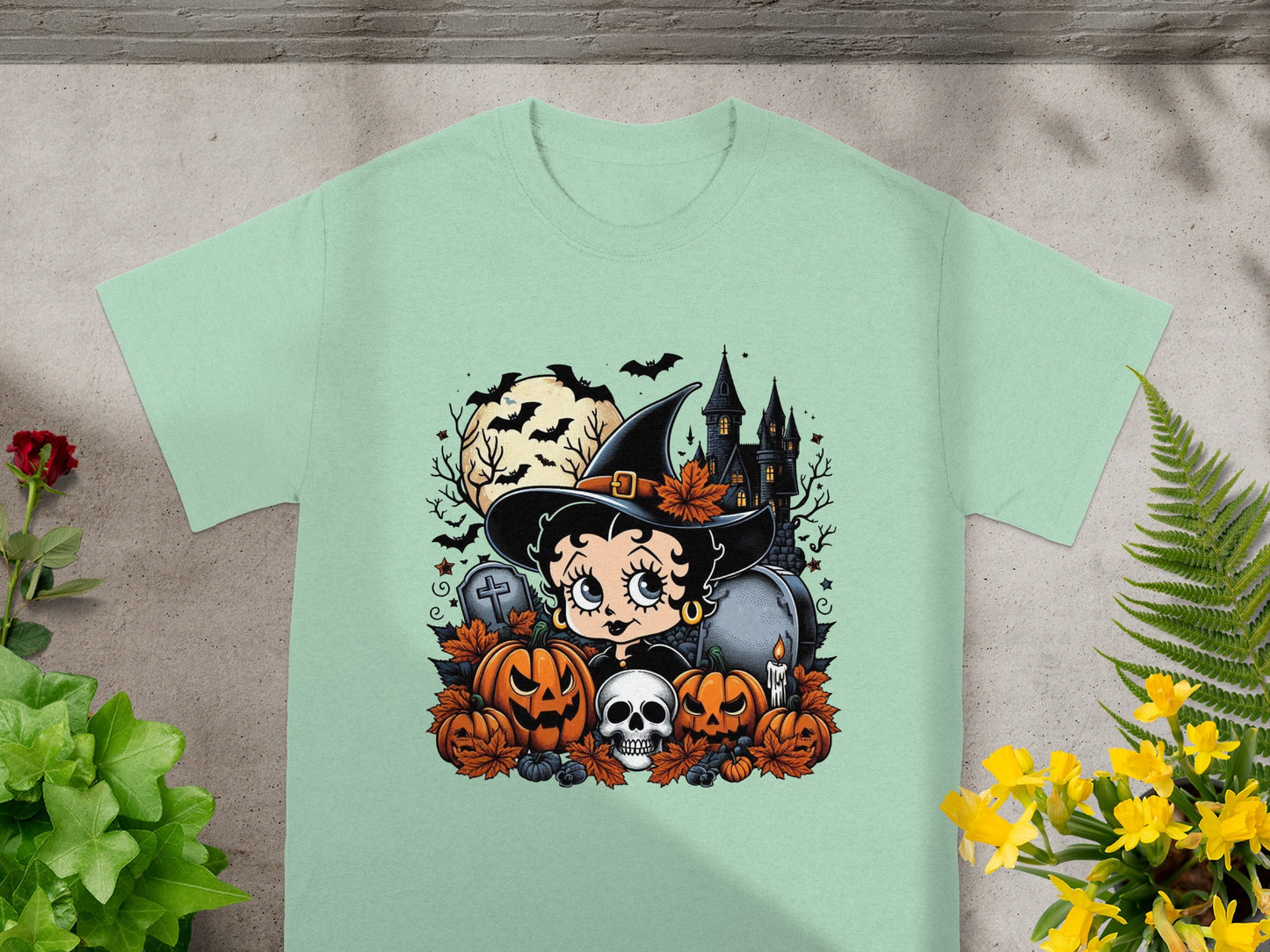 Betty Boop as a witch with pumpkins, skull, gravestones, and haunted house.