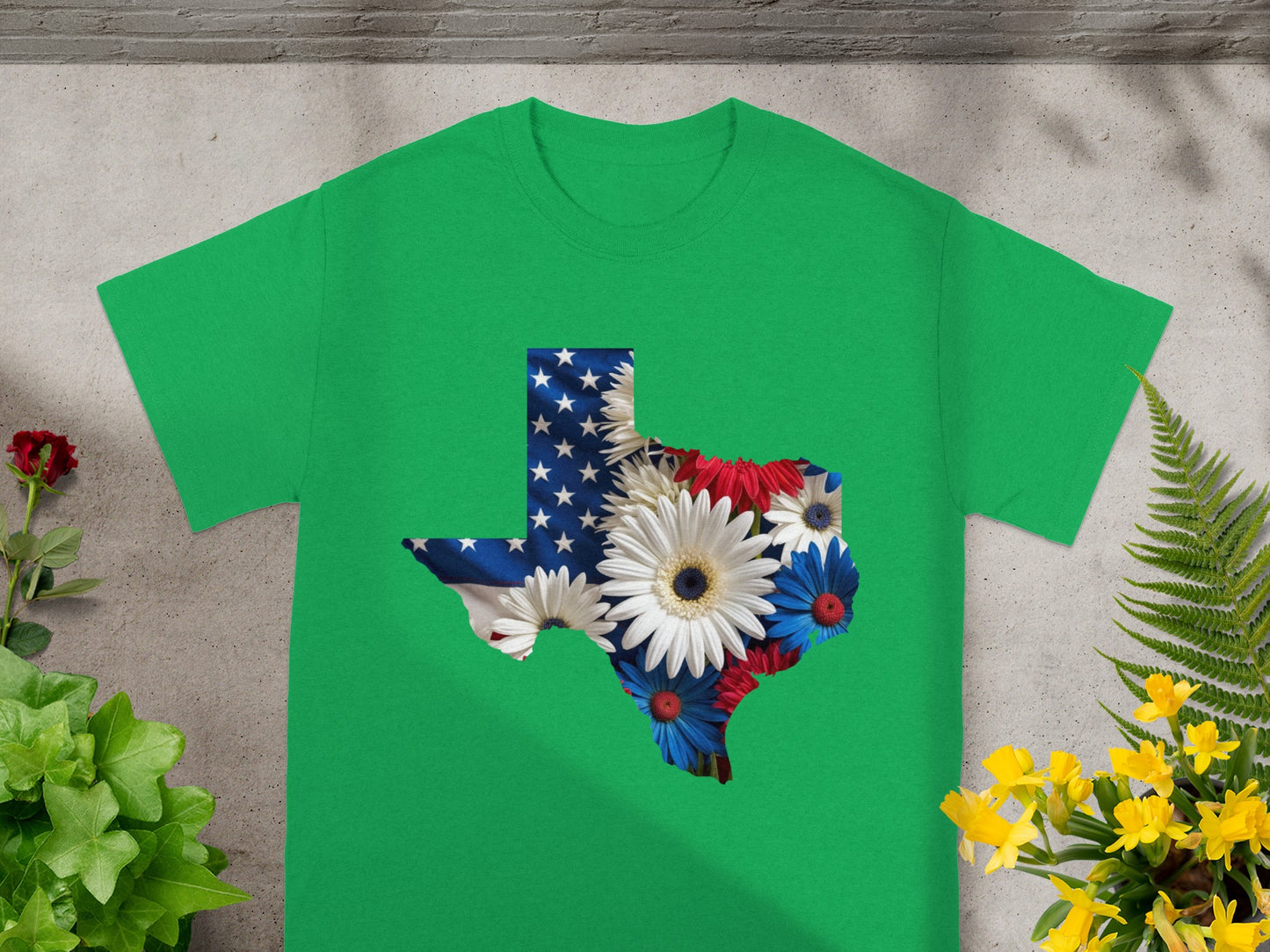Green t-shirt with Texas shape filled with American flag and patriotic flowers.