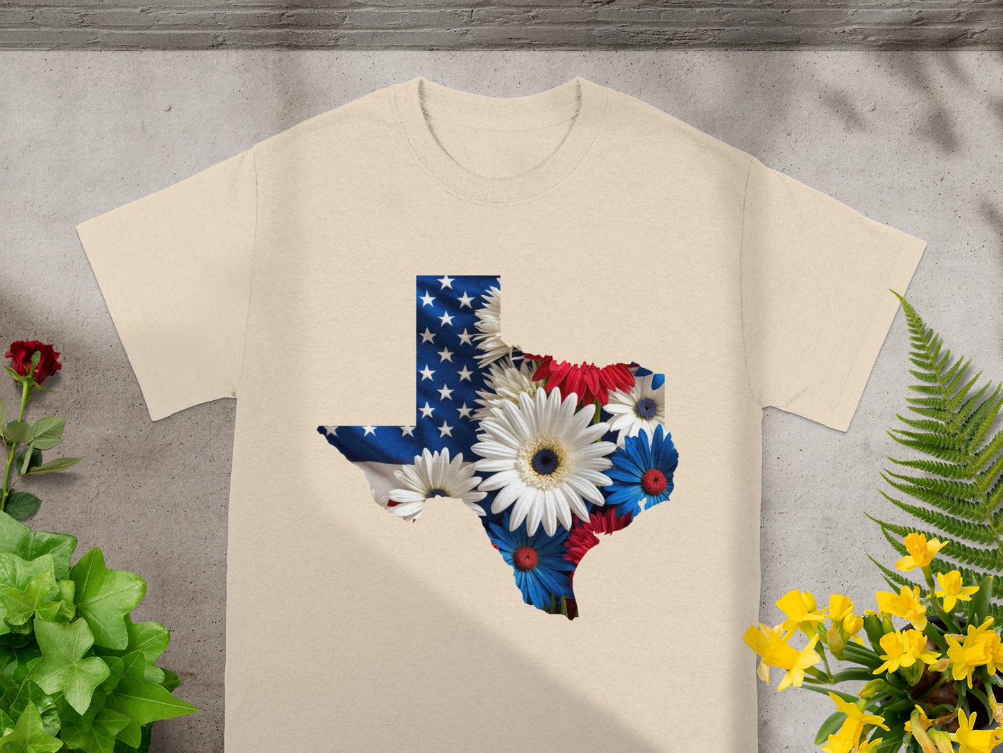 Texas shape graphic with American flag and patriotic flowers on a tan t-shirt.