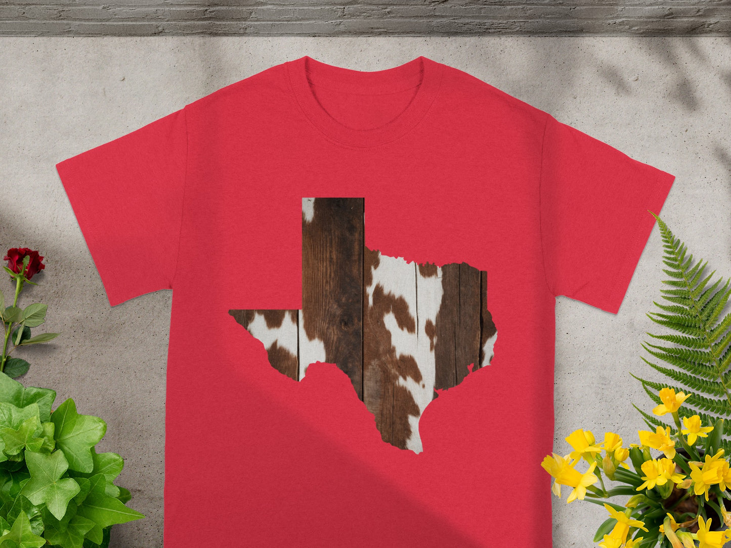 Red t-shirt with Texas outline filled with cowhide and wood texture.