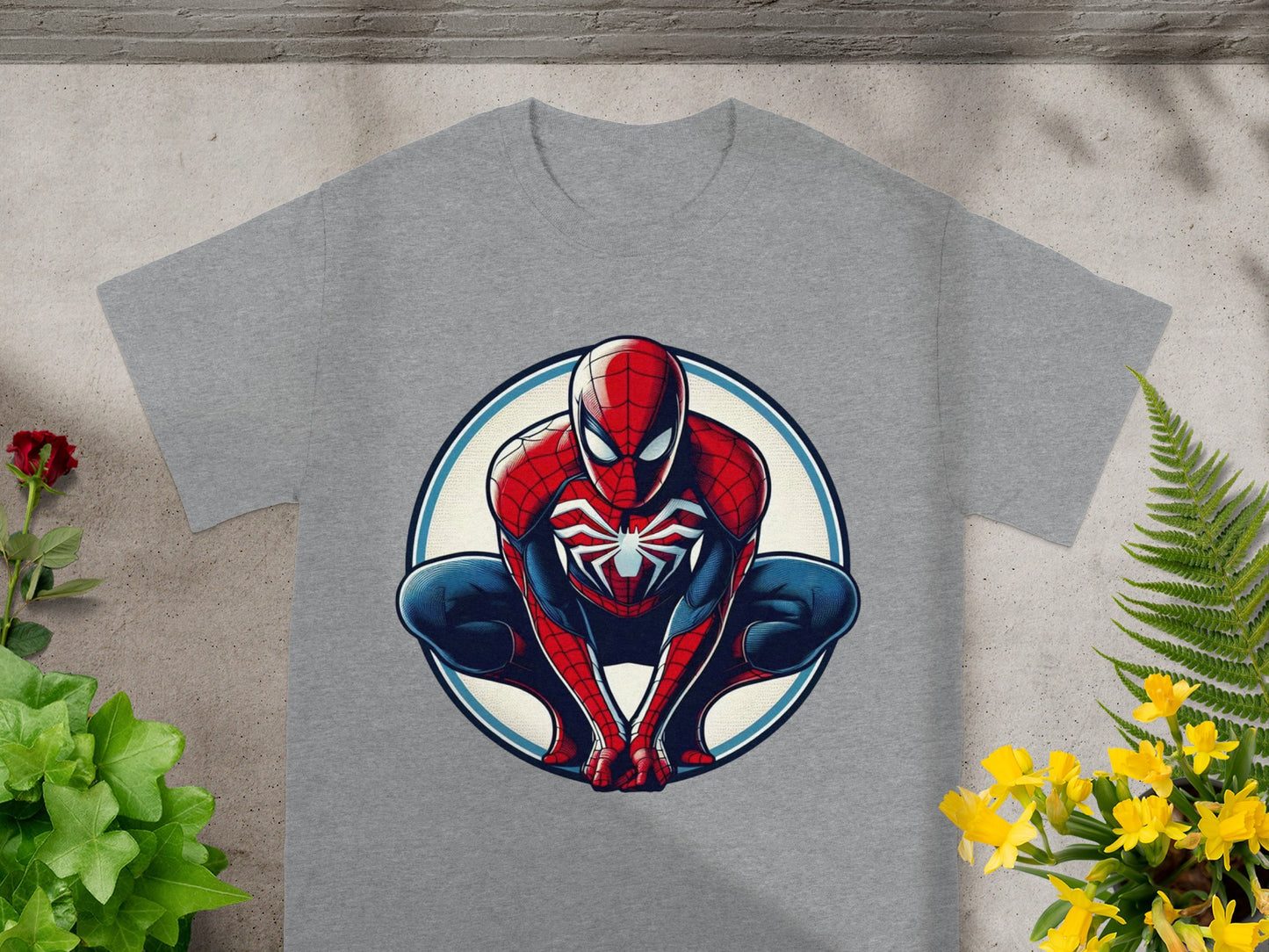 Spiderman crouching inside a circular emblem on a grey t-shirt.