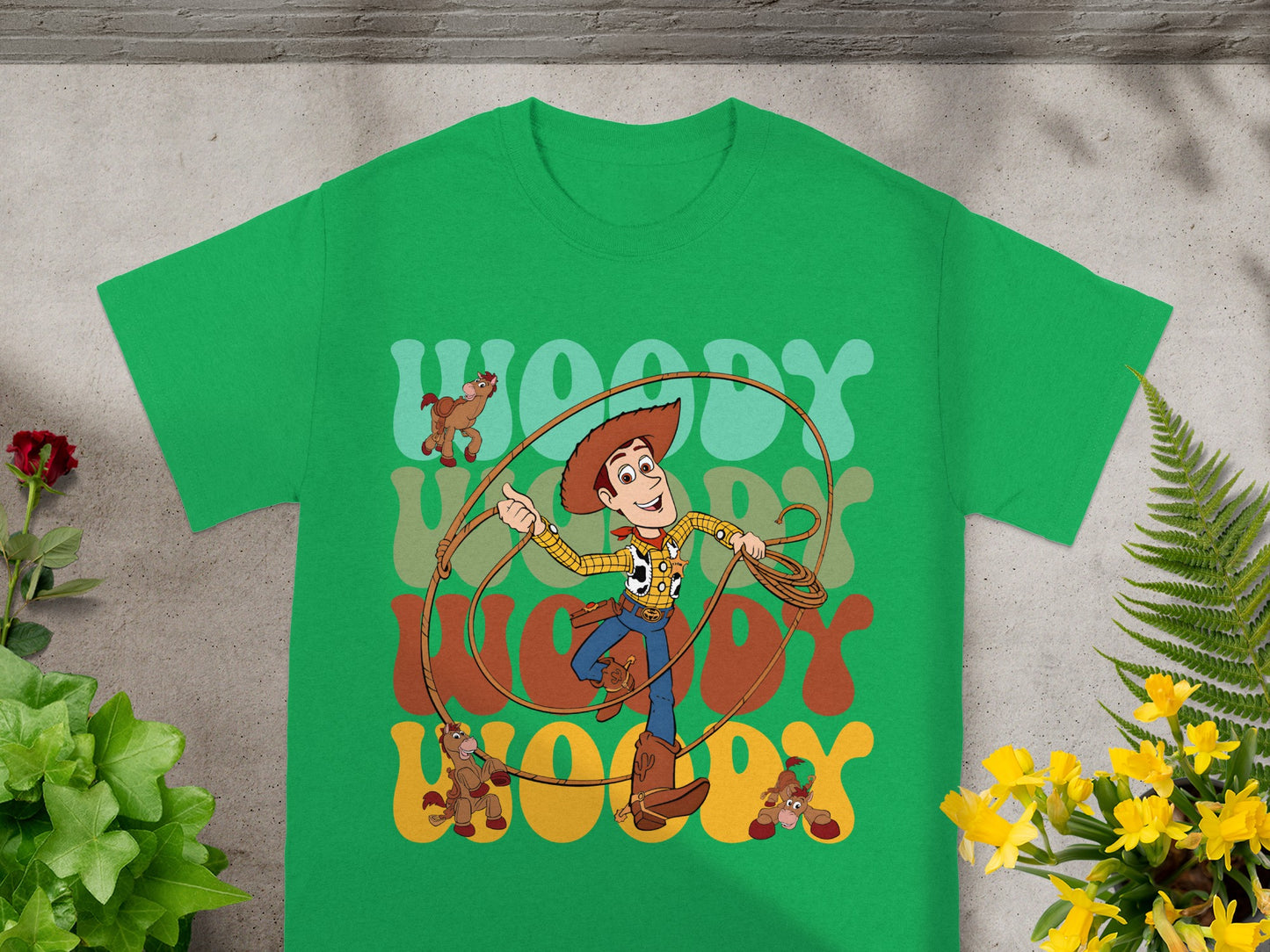 Green t-shirt with Woody from Toy Story and text "WOODY" in a retro font.