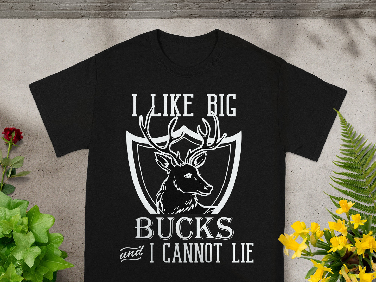 Black t-shirt with white text and deer graphic: "I LIKE BIG BUCKS and I CANNOT LIE."