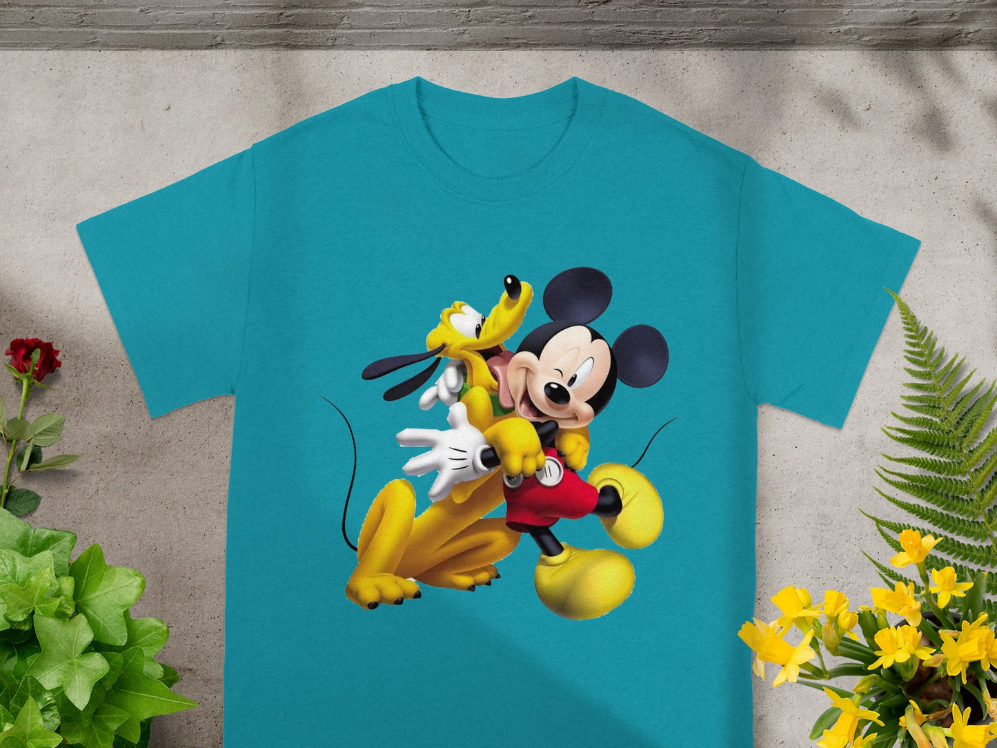 Mickey Mouse and Pluto graphic on a turquoise t-shirt.