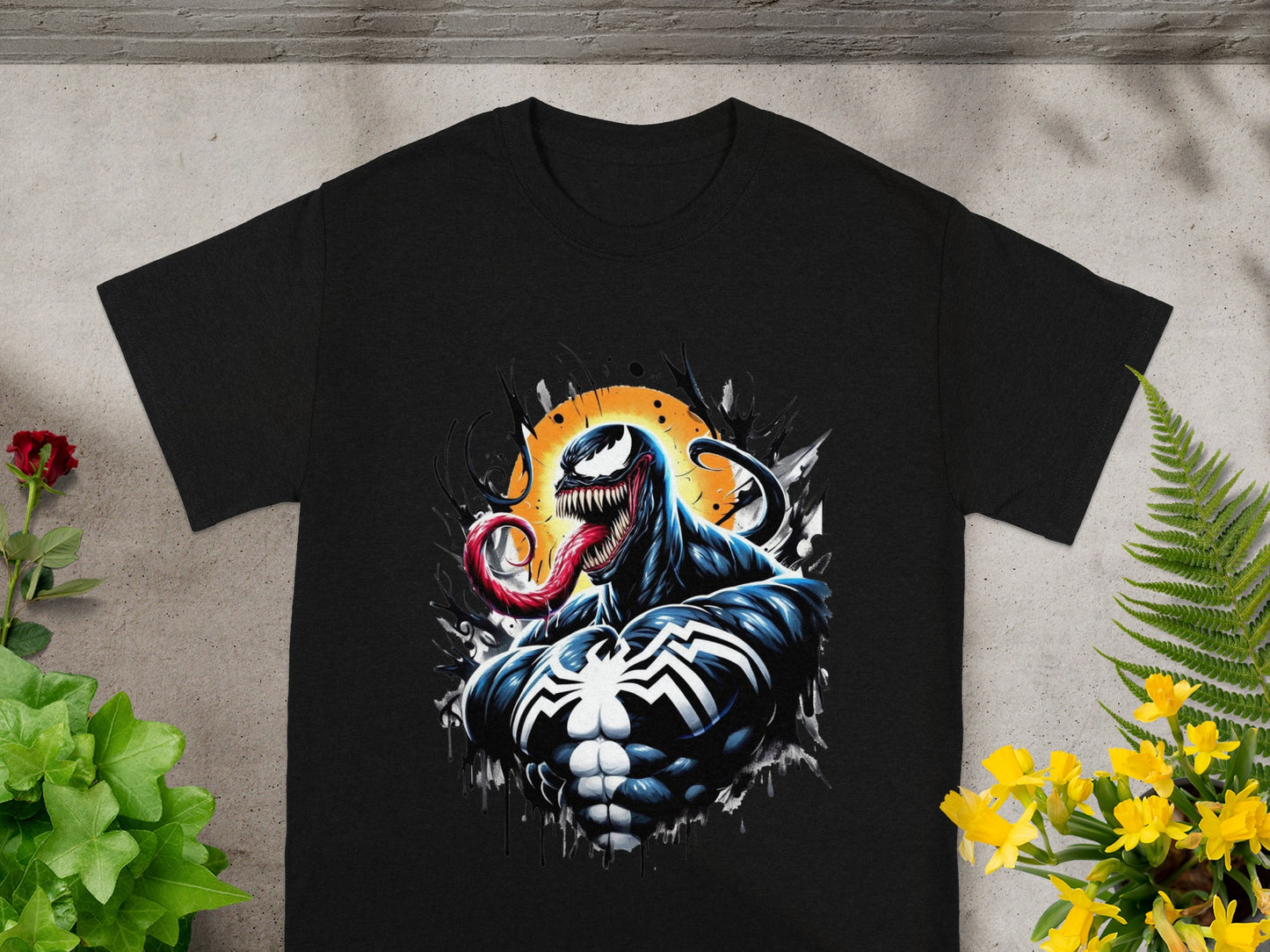 Black t-shirt with Venom artwork and yellow flowers and green plants framing it.